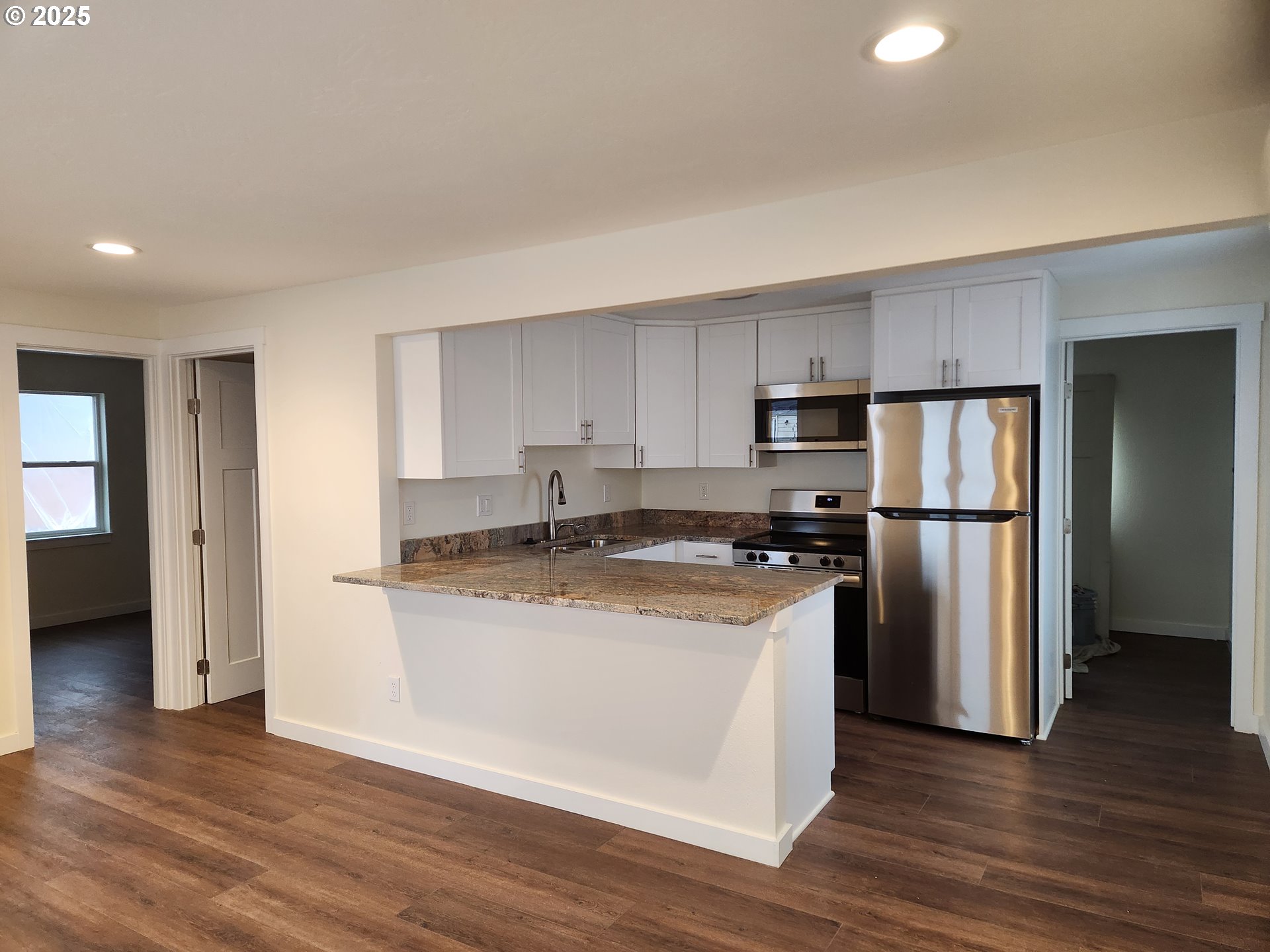 2604 J Street Springfield, OR 97477 - Photo 4 of 11 a kitchen with stainless steel appliances granite countertop a refrigerator a stove and a wooden floors