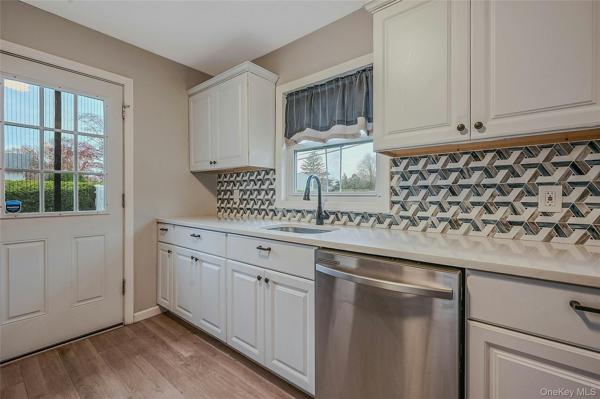 425 Blue Point Road Farmingville, NY 11738 - Photo 10 of 32 a kitchen with a sink window and cabinets
