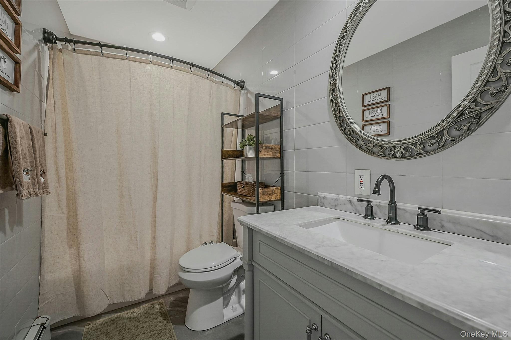 425 Blue Point Road Farmingville, NY 11738 - Photo 12 of 32 a bathroom with a toilet a sink and a mirror