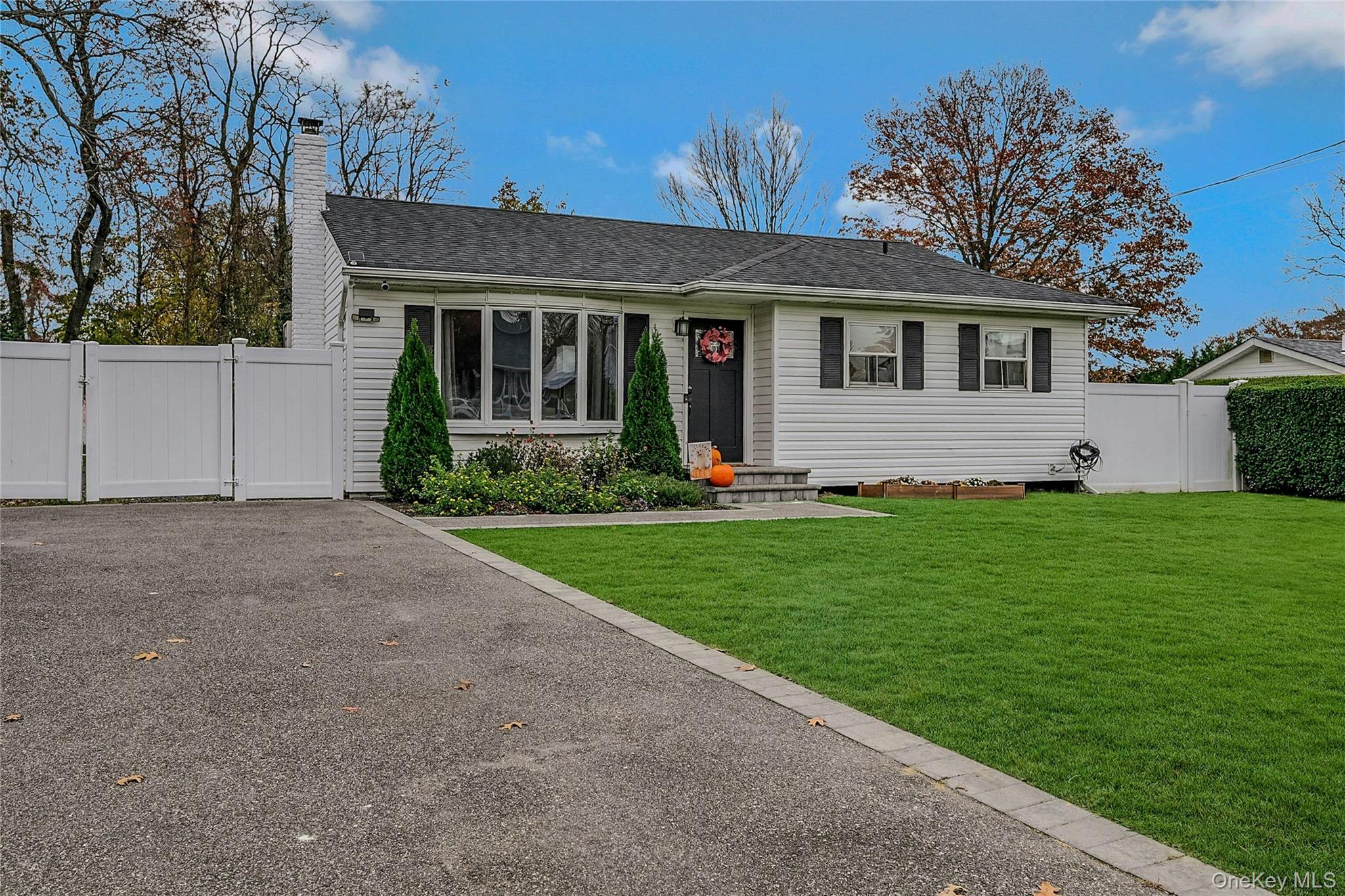 425 Blue Point Road Farmingville, NY 11738 - Photo 2 of 32 a front view of a house with a garden and plants