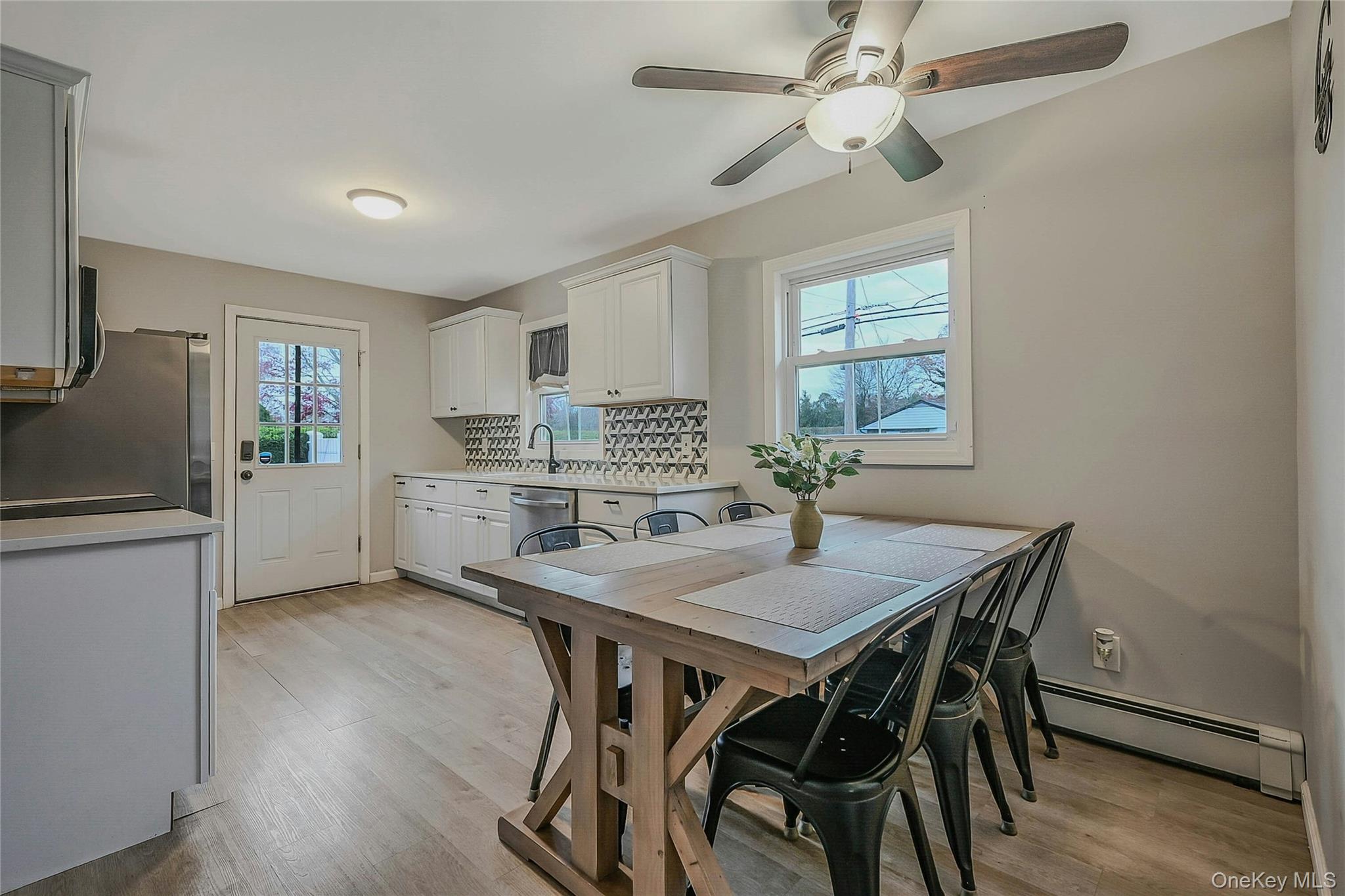 425 Blue Point Road Farmingville, NY 11738 - Photo 8 of 32 a kitchen with a table chairs refrigerator and cabinets