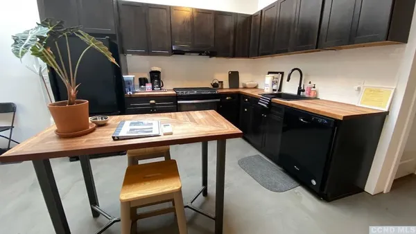 a kitchen with a sink cabinets and chair