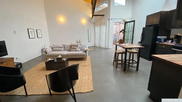a living room with furniture a large window and a flat screen tv