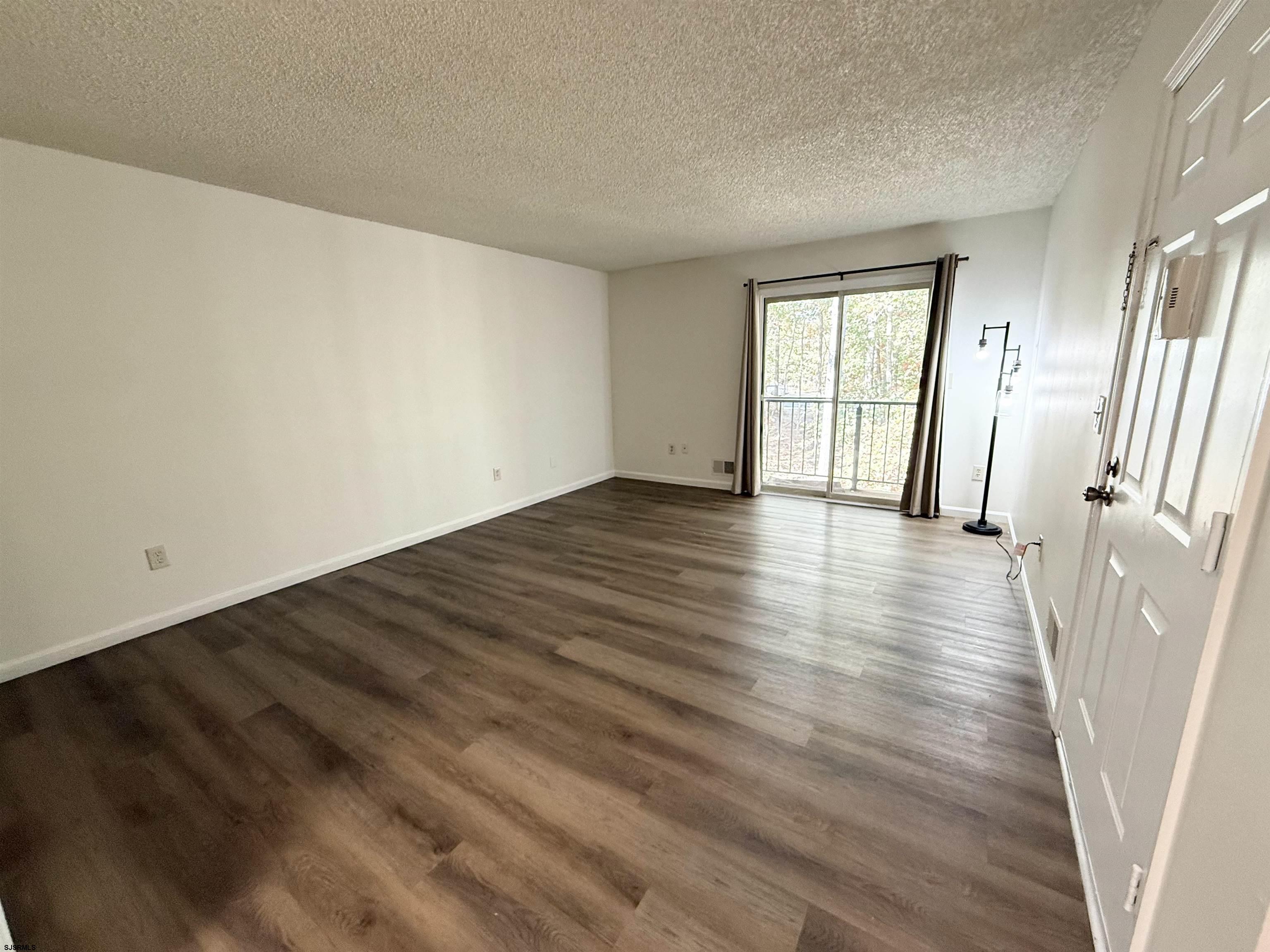 11 Colonial Court, Unit 11 Galloway Township, NJ 08205 - Photo 2 of 15 wooden floor in an empty room with a window