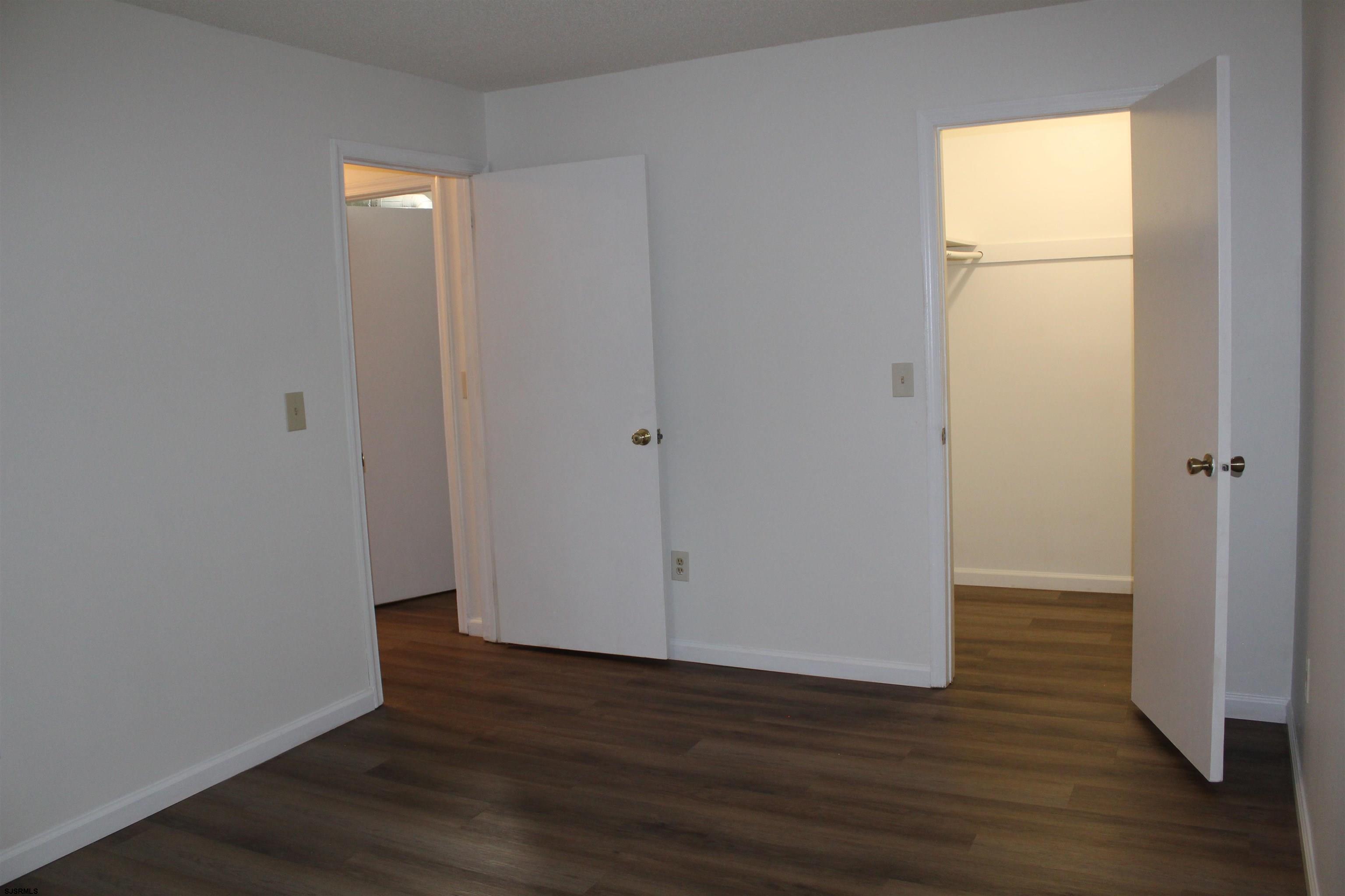 11 Colonial Court, Unit 11 Galloway Township, NJ 08205 - Photo 9 of 15 a view of an empty room with wooden floor and a window
