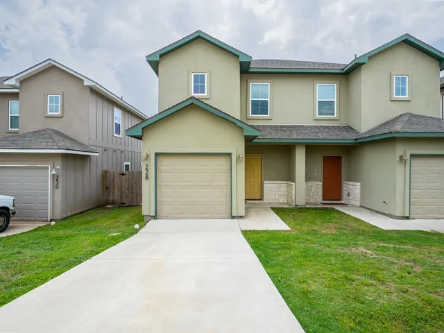 a front view of a house with a yard and garage