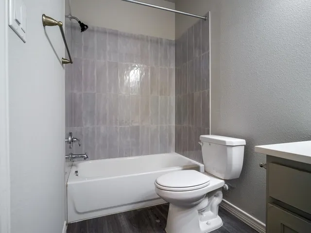 a white toilet sitting next to a bath tub