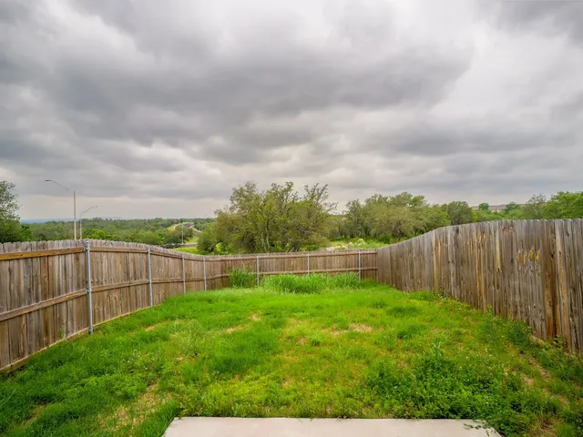a view of a backyard with a wooden fence