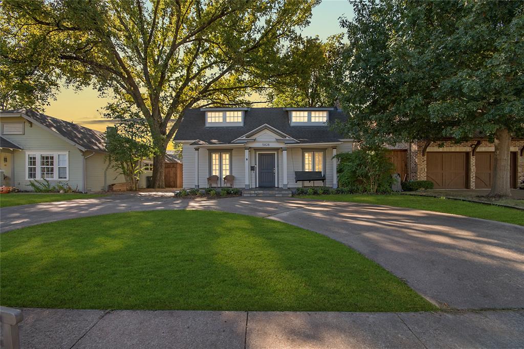 View of front facade featuring a yard and curved driveway
