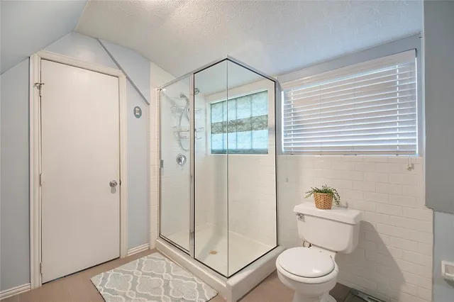 a bathroom with a toilet a sink and shower
