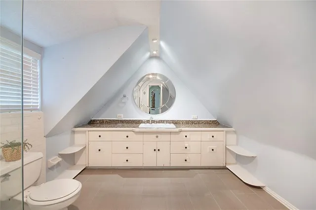 a bathroom with a sink mirror vanity and toilet