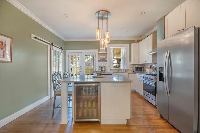 a kitchen with stainless steel appliances granite countertop a refrigerator a stove and a wooden floors