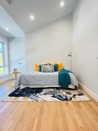 a bedroom with a bed and wooden floor