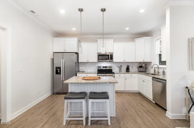 a kitchen with refrigerator cabinets and wooden floor