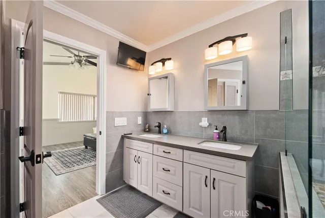 a bathroom with a double vanity sink a toilet and shower