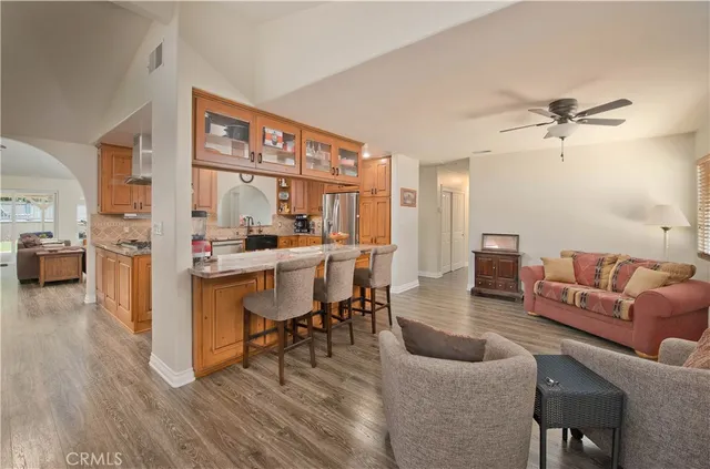 a dining room with stainless steel appliances a dining table and chairs with wooden floor