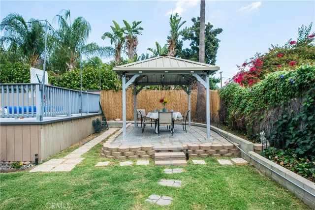 a view of a house with a backyard and sitting area