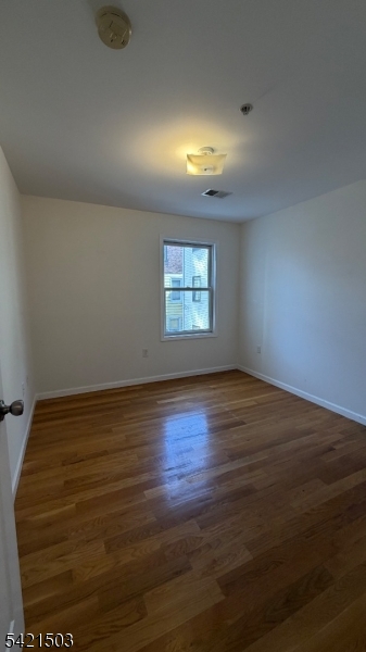 157 Lafayette Street, Unit 2 Newark, NJ 07105 - Photo 15 of 19 a view of an empty room with wooden floor and a window