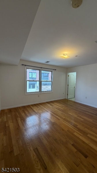157 Lafayette Street, Unit 2 Newark, NJ 07105 - Photo 16 of 19 an empty room with wooden floor and windows