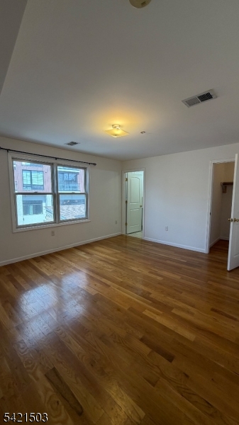157 Lafayette Street, Unit 2 Newark, NJ 07105 - Photo 17 of 19 a view of an empty room with wooden floor and a window