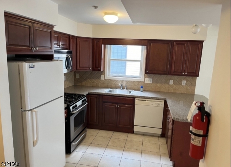 157 Lafayette Street, Unit 2 Newark, NJ 07105 - Photo 5 of 19 a kitchen with stainless steel appliances granite countertop a refrigerator stove a sink and dishwasher