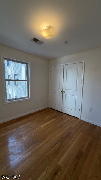 157 Lafayette Street, Unit 2 Newark, NJ 07105 - Photo 10 of 19 an empty room with wooden floor and windows