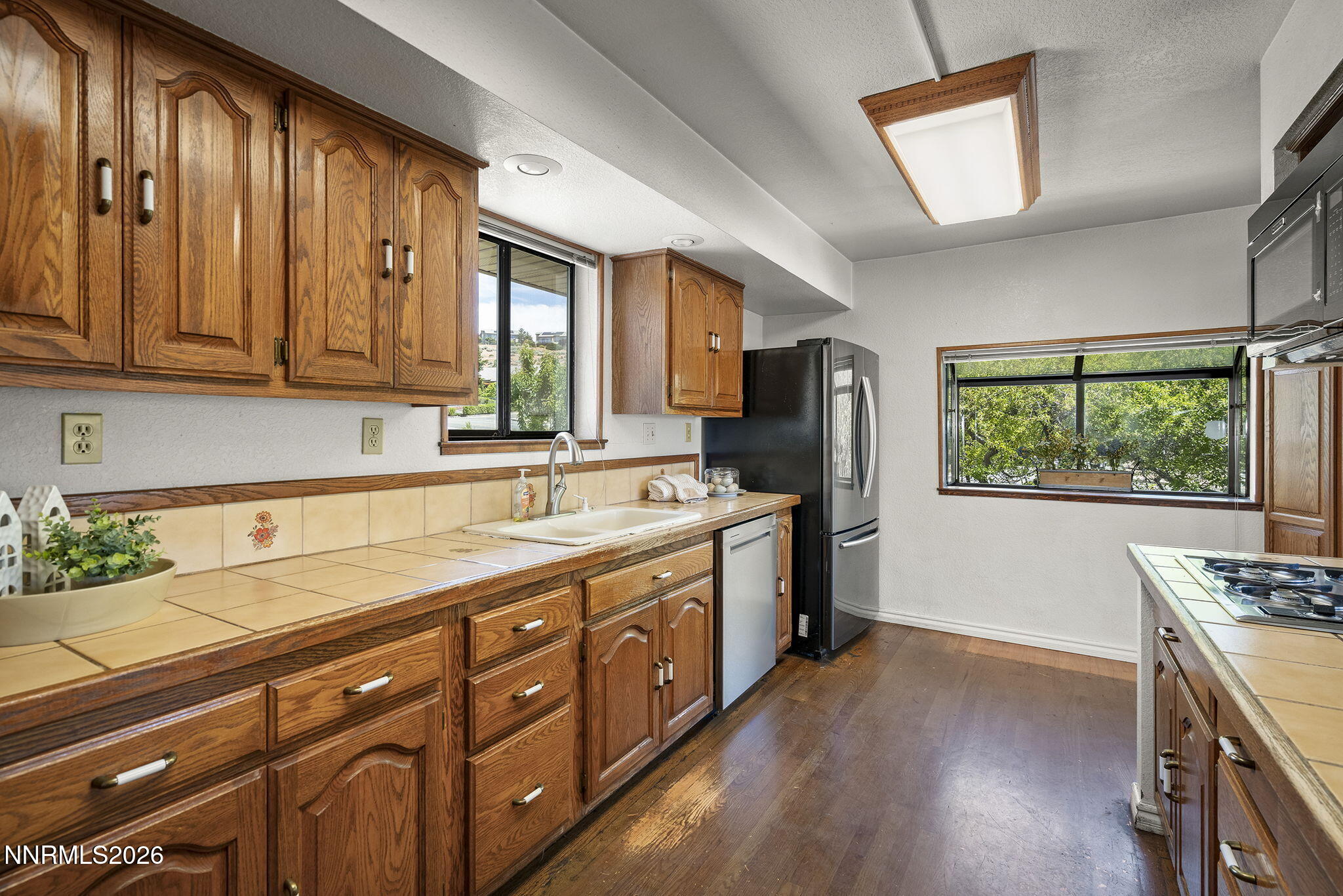 2985 Socrates Drive Reno, NV 89512 - Photo 6 of 52 a kitchen with stainless steel appliances granite countertop a refrigerator a sink dishwasher a stove and white countertops with wooden floor