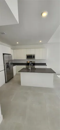a view of kitchen with stainless steel appliances granite countertop a stove and a refrigerator