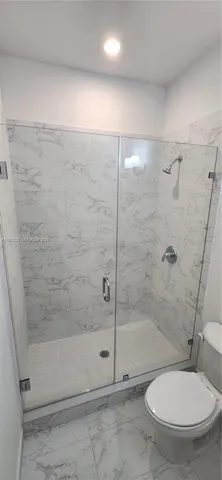 a bathroom with a toilet and a shower