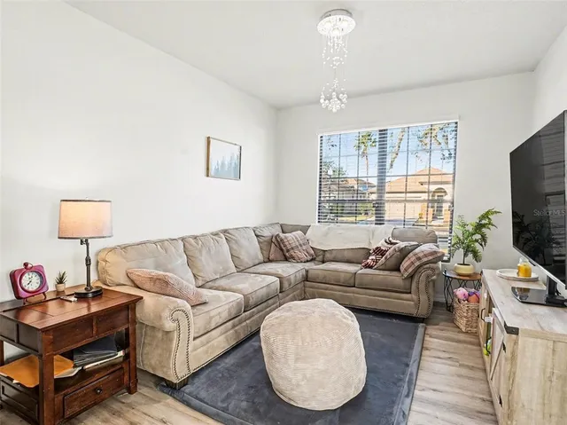 a living room with furniture a flat screen tv and a window