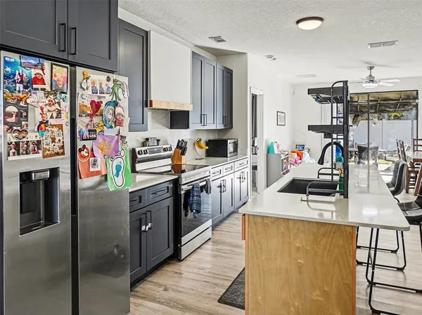a kitchen with stainless steel appliances granite countertop a sink stove and refrigerator