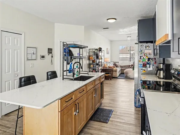 a kitchen with stainless steel appliances a sink a stove top oven a counter space and cabinets