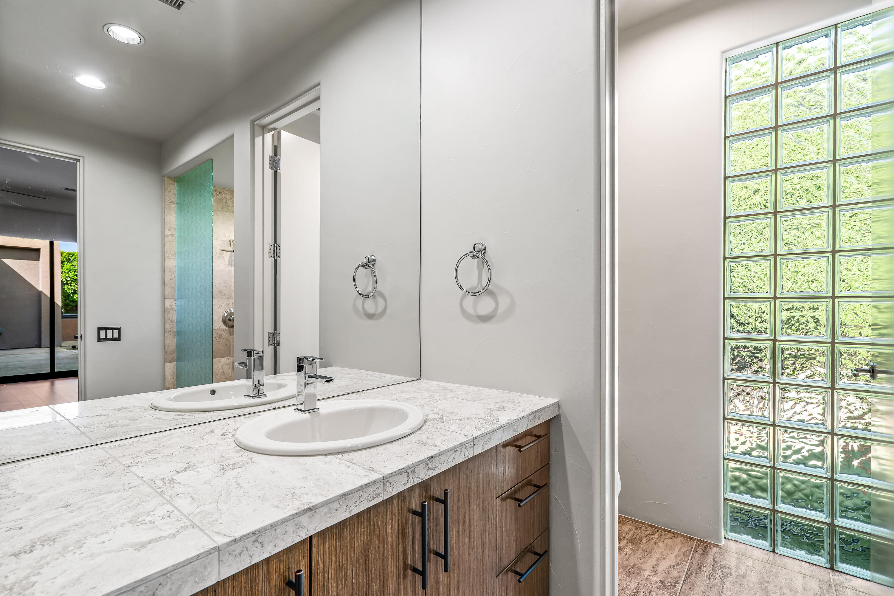 79200 Jack Rabbit Trail La Quinta, CA 92253 - Photo 45 of 76 a bathroom with a granite countertop sink a large mirror and a shower
