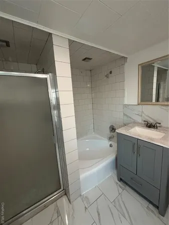 a spacious bathroom with a granite countertop sink a bathtub and shower