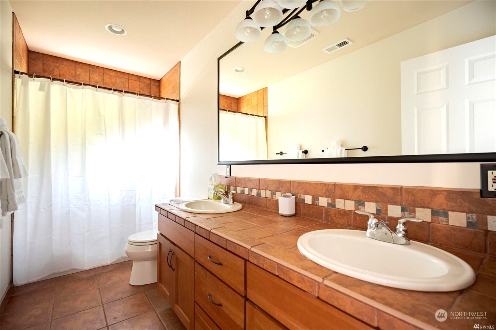 1239 Northwest 119th Street Seattle, WA 98177 - Photo 22 of 36 a bathroom with a double vanity sink and a mirror