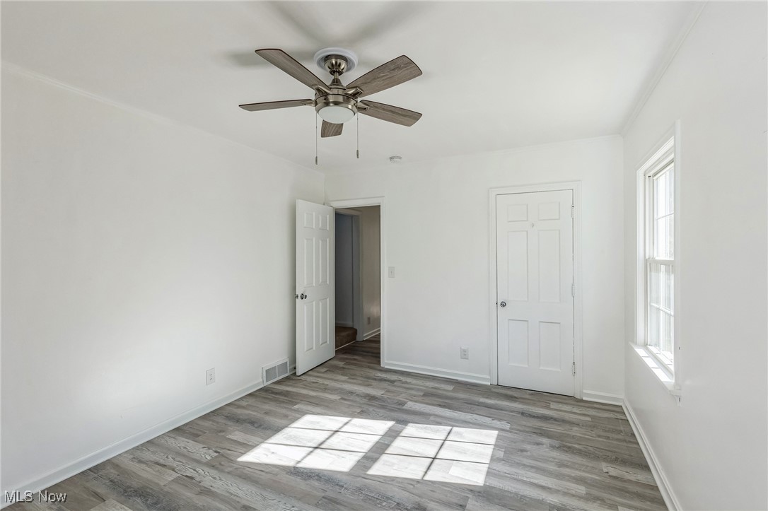 106 Berkley Road Elyria, OH 44035 - Photo 8 of 16 Unfurnished bedroom featuring multiple windows, light wood-type flooring, and ceiling fan