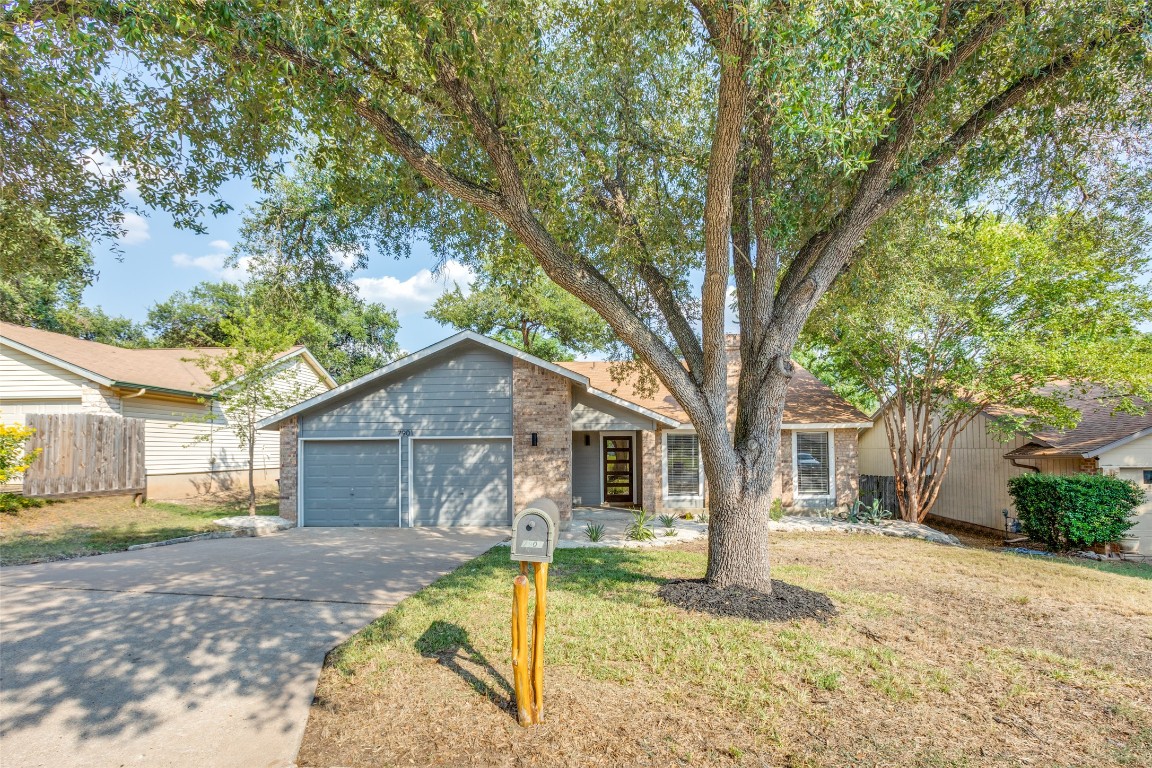 Mid-century modern home with brick siding, concrete driveway, and an attached garage