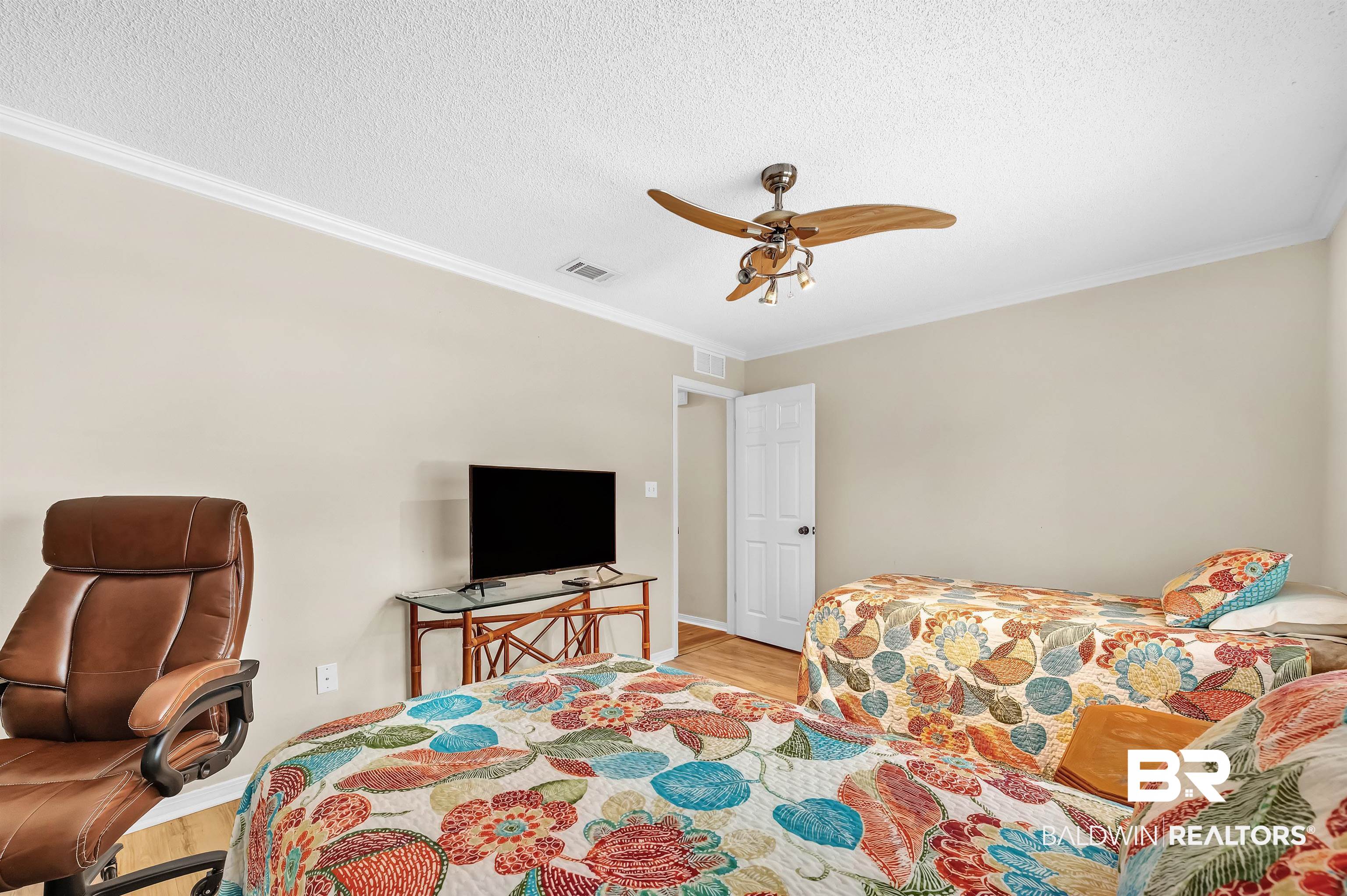 24551 Wolf Bay Drive Foley, AL 36535 - Photo 44 of 59 Bedroom with wood finished floors, ornamental molding, a textured ceiling, and ceiling fan