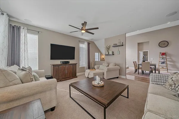 a living room with furniture a flat screen tv and a window