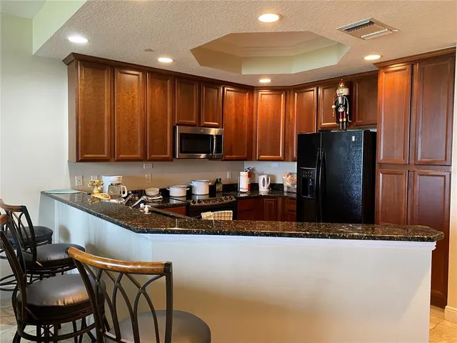 a kitchen with granite countertop wood cabinets and a stove top oven