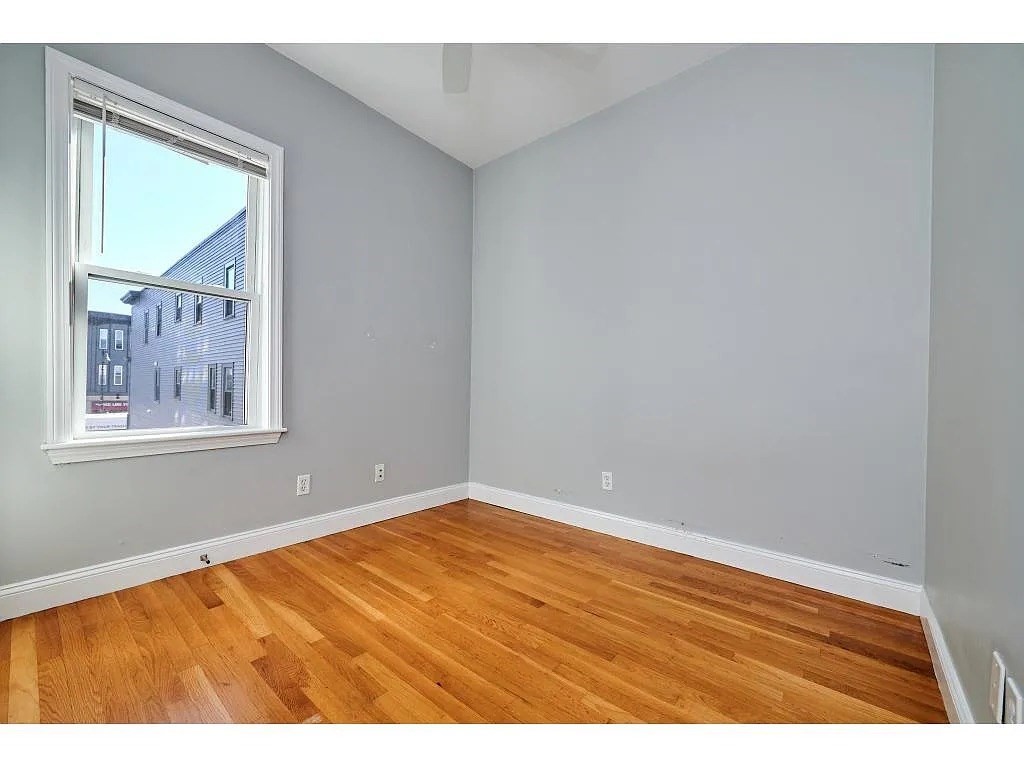 5-7 Transit Street, Unit 5 2 Boston, MA 02127 - Photo 3 of 7 a view of an empty room with wooden floor and a window