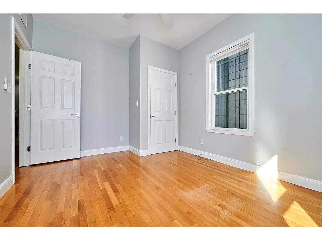 5-7 Transit Street, Unit 5 2 Boston, MA 02127 - Photo 4 of 7 a view of an empty room with wooden floor and a window