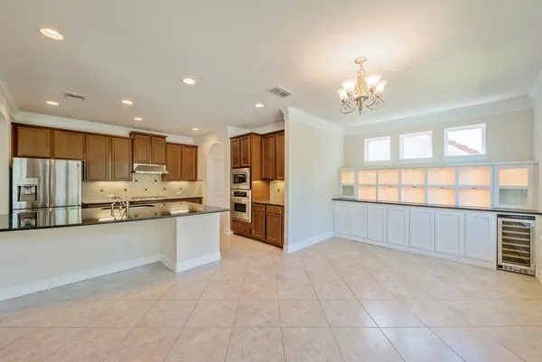 a large kitchen with granite countertop a large counter top stainless steel appliances and cabinets