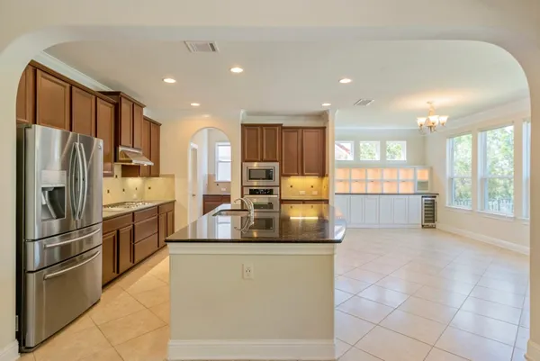 a kitchen with stainless steel appliances granite countertop a refrigerator and a stove