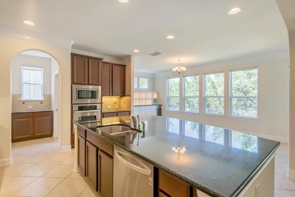 a kitchen with kitchen island granite countertop a stove window and cabinets