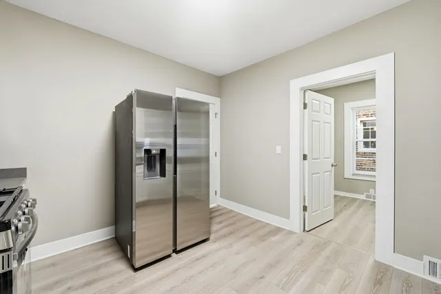 an empty room with wooden floor and a hallway