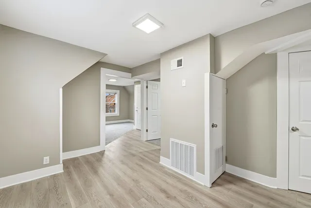 a view of a hallway with wooden floor and closet area