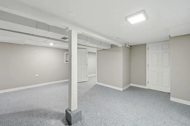 a view of a kitchen with refrigerator and white cabinets