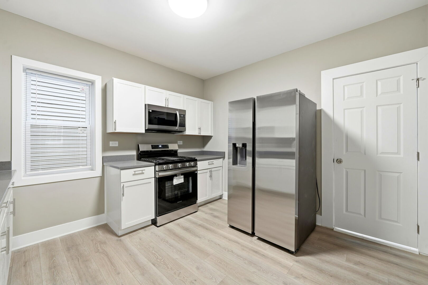 1217 North Harding Avenue Chicago, IL 60651 - Photo 10 of 45 a kitchen with a refrigerator stove and microwave