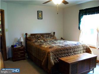 140 Harris Road Mannington, NJ 08079 - Photo 7 of 12 a bed sitting in a bedroom next to a window
